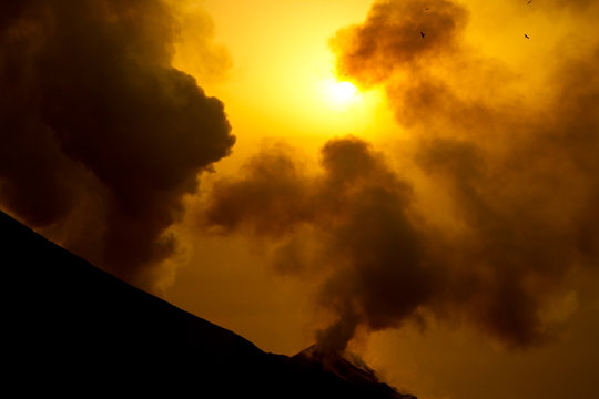 smoking volcano at sunset