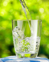 Glass of water on nature background