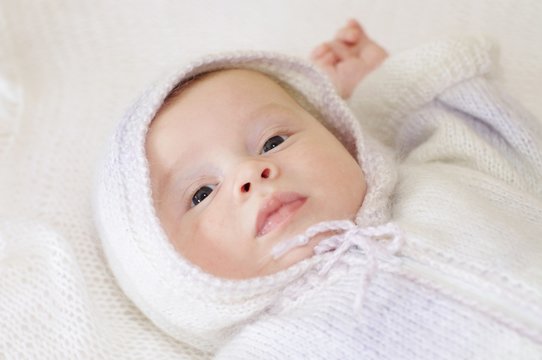 Portrait of baby in a knitted suit with a hood (2 months)
