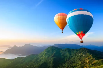 Foto auf Acrylglas Ballon Bunte Heißluftballons fliegen über den Berg