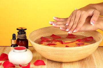 Obraz na płótnie Canvas spa treatments for female hands, on yellow background