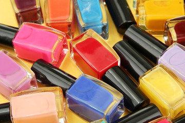 Group of bright nail polishes, on yellow background