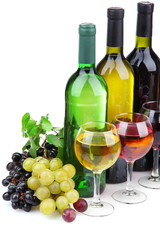 bottles and glasses of wine and assortment of grapes, isolated