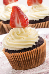 Cupcake mit einer halben Erdbeere