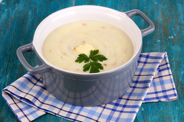 Mashed potatoes in saucepan on blue wooden table