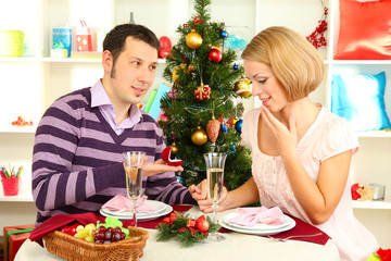 Young man makes proposal to marry girl at table near Christmas