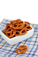 Tasty pretzels in white bowl isolated on white