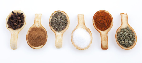 Biscuit spoons with herbs in a row