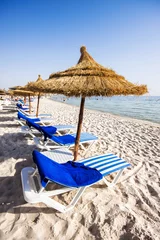 Fototapete Tunesien Schöner Strand mit Strandkörben und strohgedeckten Sonnenschirmen in Port El K