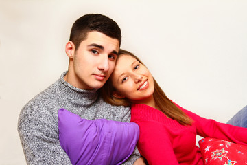 Obraz premium Smiling boy and girl sitting with Christmas pillows isolated on