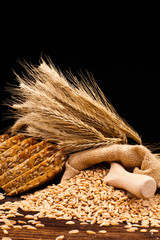 assortment of baked bread on wooden table and black background