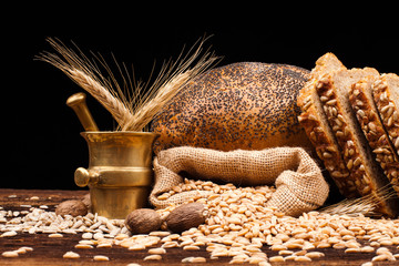 assortment of baked bread on wooden table and black background