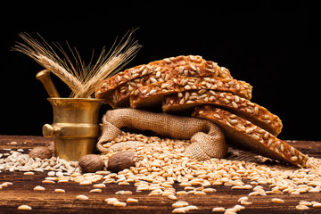 assortment of baked bread on wooden table and black background