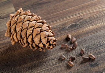 Cedar cone and nuts on wooden background