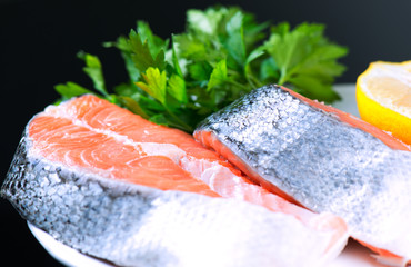 Salmon stake on plate on black background