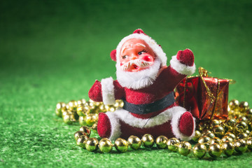 Santa Claus with gifts box on green background.