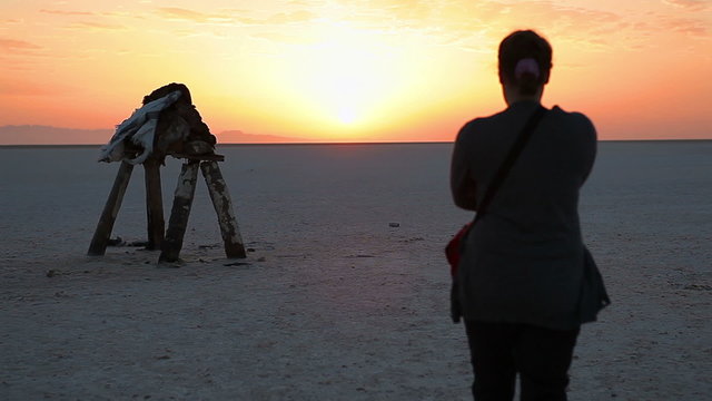 Girl meeting sunrise at the dry lake Chott el Djerid in Tunisia