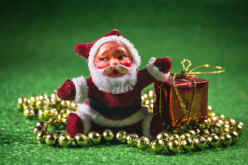 Santa Claus with gifts box on green background.