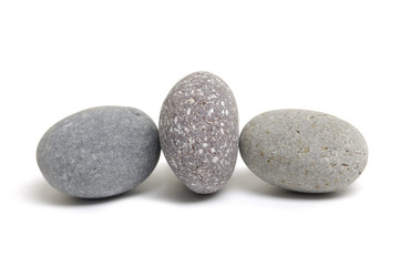 Fototapeta na wymiar three pebbles placed on white