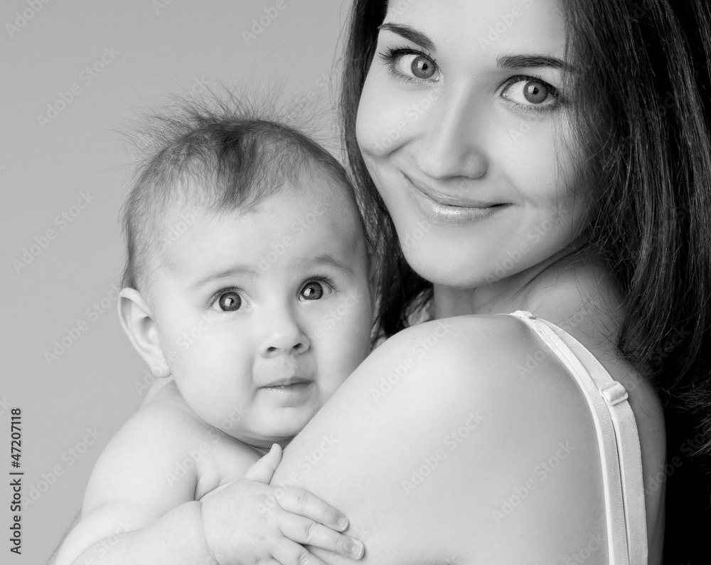 Wall mural young mother hugging baby