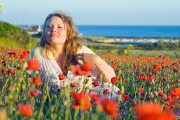 Naklejka na ściany i meble Girl with flowers near the sea