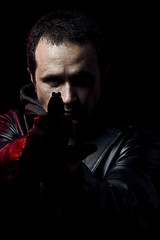 Fototapeta na wymiar Robber with gun holding out hand against a black background