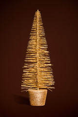 golden toy christmas tree on dark brown