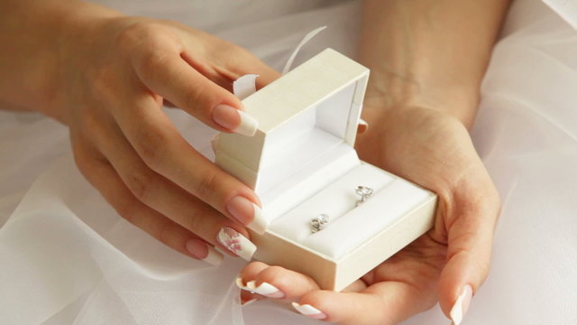 Bride holding a box with earrings in her hands