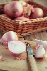 Onion cut in half with a knife on a chopping board