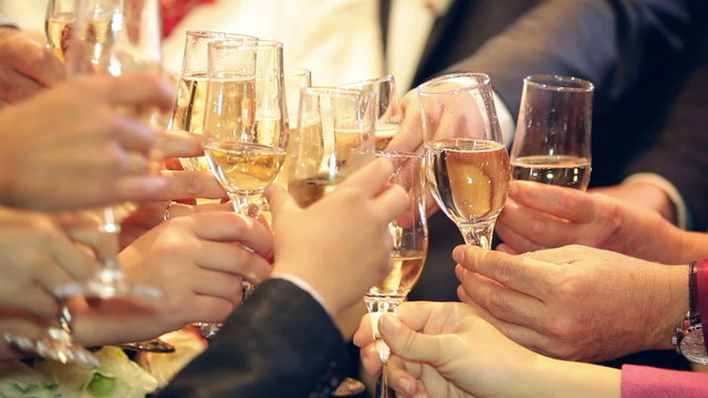 Guests raising glasses for a toast on a wedding