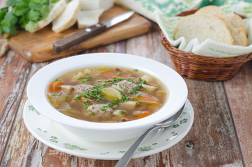 Plate of vegetable soup with meatballs on the wooden table