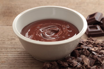 CIOCCOLATO FUSO SU TAVOLO DI LEGNO