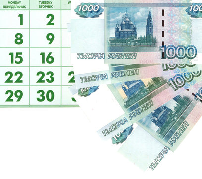 Купюры достоинством 1000 рублей на фоне календаря