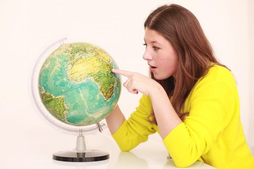 Mädchen zeigt mit Finger auf Globus
