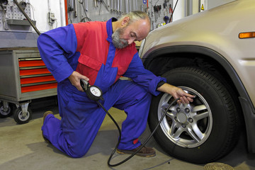 garagiste vérifiant la pression des pneus
