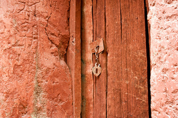 Vintage metal door chain handle at orange painted wooden door