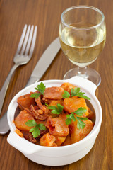 seafood stew in the bowl with parsley and glass of wine