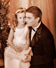 Kid with father near Christmas tree.