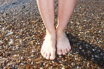 legs walking on beach stones close-up