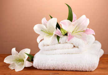 Fototapeta na wymiar stos ręczniki z różowego lily na brązowym tle