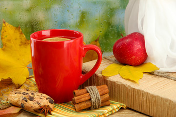 cup of hot tea and autumn leaves, on rain background