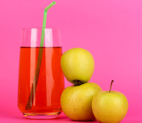 Useful apple juice with apples around on pink  background