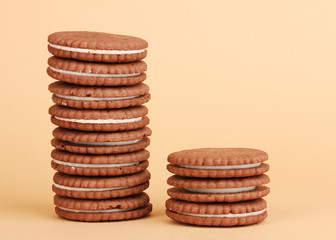 Chocolate cookies with creamy layer on beige background
