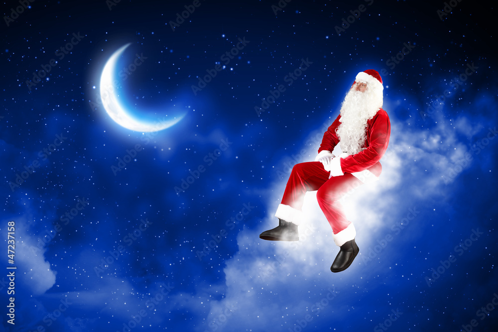 Wall mural photo of santa claus sitting on the moon