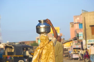 Deurstickers vrouw die een waterpot op haar hoofd draagt © travelview