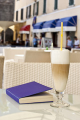 Breakfast latte. Purple book on the table