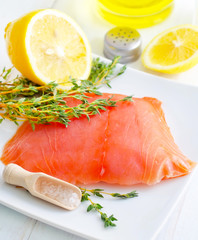Raw salmon on the white plate with thyme and salt