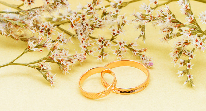 Gold wedding rings and branch flowers