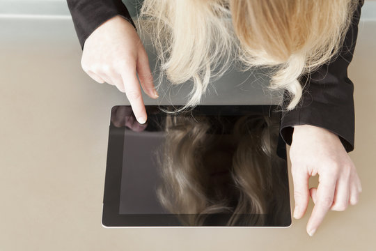 Frau berührt mit Finger das Display eines Tablet PC´s - Powered by Adobe