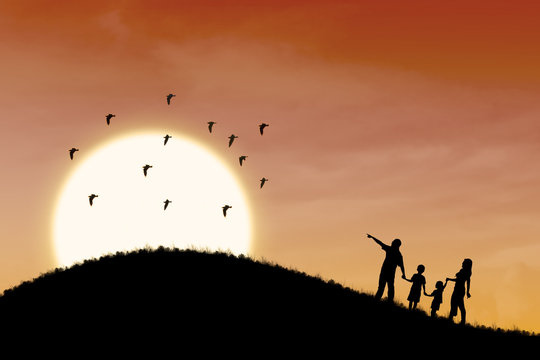 Happy family silhouette with sunset landscape